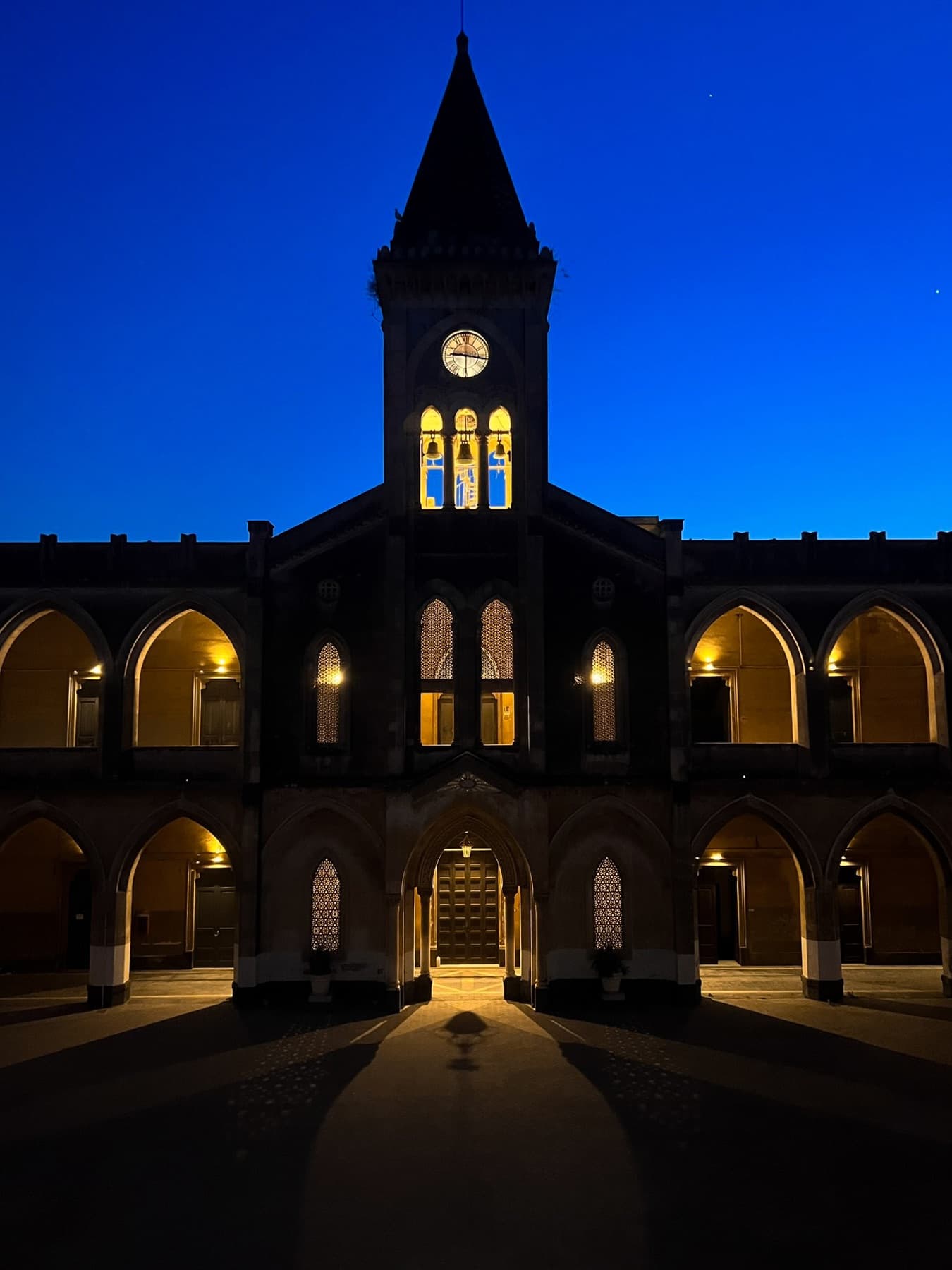 The historic courtyard and tower of the Istituto dei Ciechi lit at night.